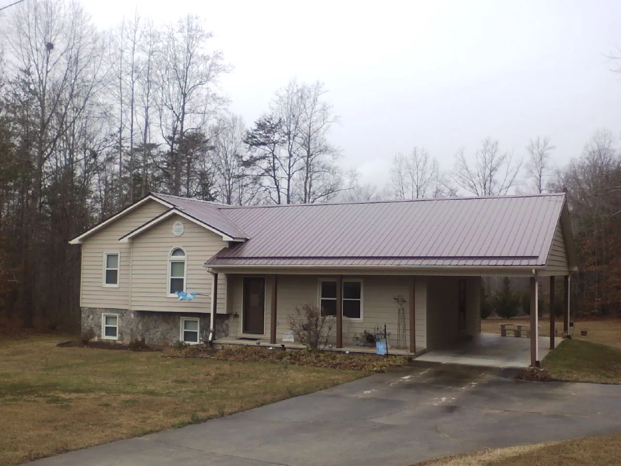 Burgundy metal roof on a tan split level home with an attached carport in Breinigsville