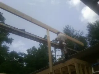 Carpenter setting a ridge beam over a new addition frame — Ice Dam Removal by Roofing Brothers in Breinigsville