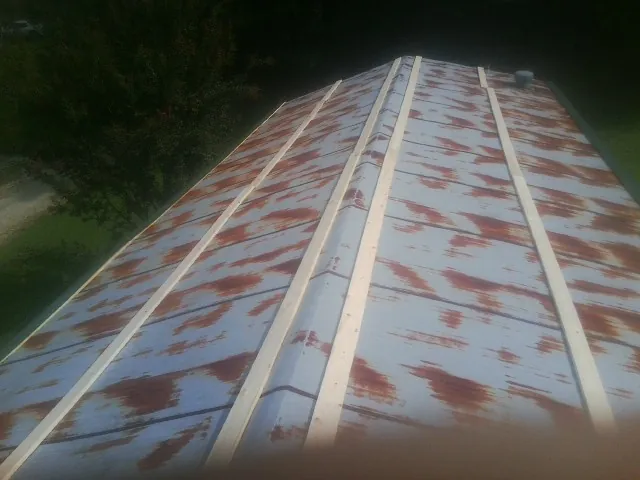 Rusted metal roof panels with new wood purlins before replacement — Storm Damage Roof Repair in Breinigsville by Roofing Brothers