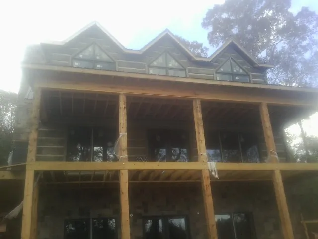 Dormers and porch framing on a large log home under construction — Roof Coating work by our crew in Breinigsville